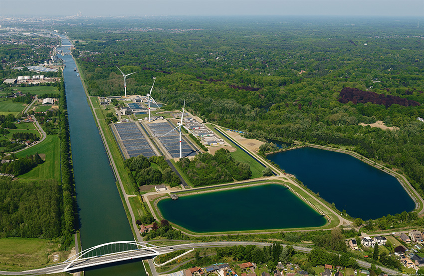 Foto van bovenaf met water, windmolens en zonnepanelen